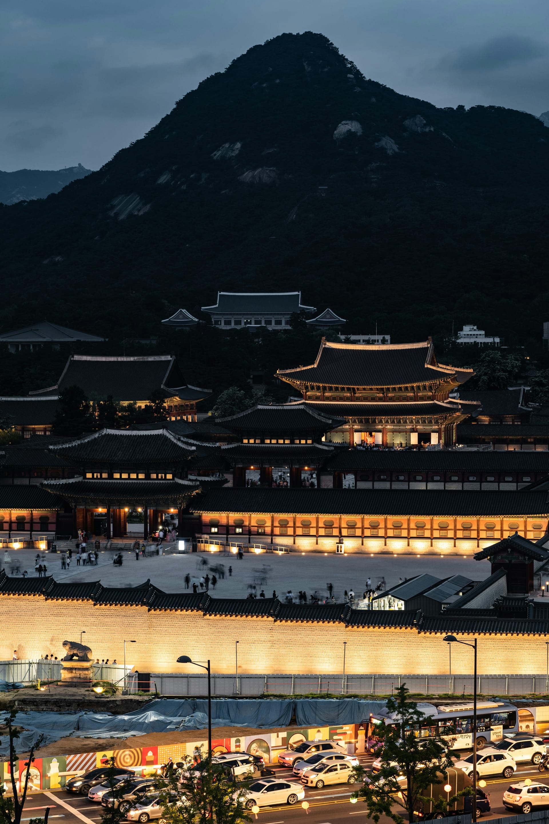 The colourful royal palace of Gyeongbokgung in Seoul with traditional Korean roofs and modern Seoul skyline behind